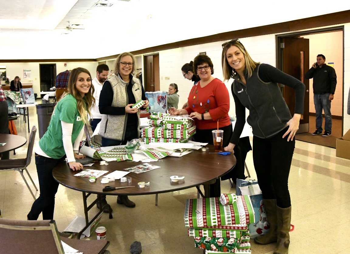 A table of smiling volunteers at the Ben Curtis Family Foundation Wrap-A-Thon